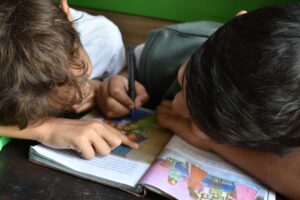 Two children learning in a book together