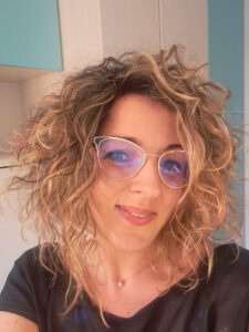 Lorena García, specialist in Early Childhood and Spanish Language Education, smiling with curly blonde hair and glasses